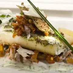 Wykwintne danie z rybą halibut, podane z kurkami, pomidorkami i cytryną.