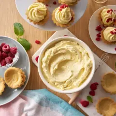 Krem russel w misce, obok babeczki, maliny i listki mięty. Idealne składniki na pyszny deser.