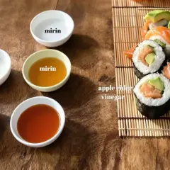 Zastanawiasz się, czym zastąpić ocet ryżowy? Na zdjęciu widać miseczki z octem, mirinem, sokiem z cytryny i jabłkowym, a obok sushi.