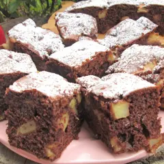 Szybkie i tanie ciasto na dużą blachę z jabłkami i kakao, posypane cukrem pudrem. Idealne na deser.
