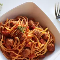 Pyszne spaghetti z klopsikami w sosie pomidorowym, doprawione ziołami. Idealne na szybki obiad, z dodatkiem przypraw do spaghetti.