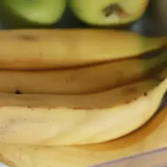 Pęk bananów w lodówce, obok zielonych jabłek. Czy banany można trzymać w lodówce? Tutaj są dowody.