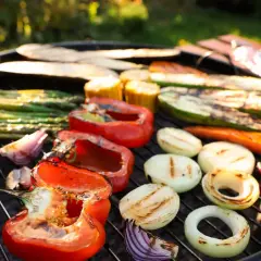 Pyszne warzywa na grilla: papryka, cukinia, szparagi, cebula i kukurydza pieczone na ruszcie w słoneczny dzień.