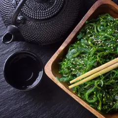 Sałatka z wodorostów wakame, posypana sezamem, gotowa do spożycia z czarną herbatą. Wakame co to? To pyszne, zdrowe algi morskie.