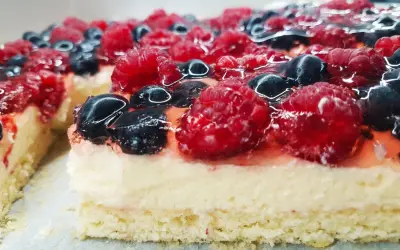 Pyszny biszkopt z galaretką bez kremu, obficie udekorowany malinami i borówkami. Idealny na letnie popołudnie.