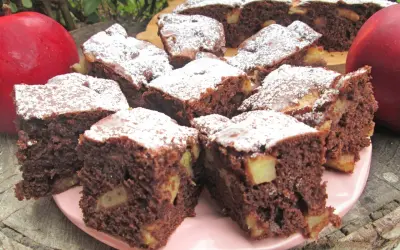 Szybkie i tanie ciasto na dużą blachę z jabłkami i kakao, posypane cukrem pudrem. Idealne na deser.