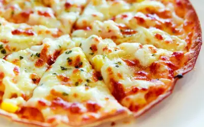 Pyszna pizza z tortilli na patelni, z ciągnącym się serem i ziołami. Idealna na szybki obiad.