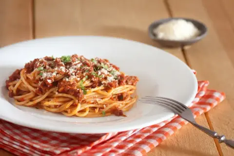 Porcja spaghetti bolognese, posypana parmezanem i natką pietruszki. Idealne na obiad, znasz już jego spaghetti bolognese kcal?