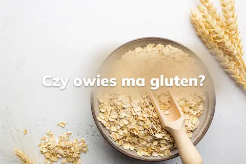Miseczka płatków owsianych i kłosy zbóż. Pytanie "Czy owies ma gluten?" sugeruje dyskusję o jego zawartości.