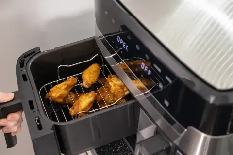 Złociste skrzydełka kurczaka w airfryerze, gotowe do podania. Pyszne dania z airfryer to szybki sposób na chrupiące przysmaki.