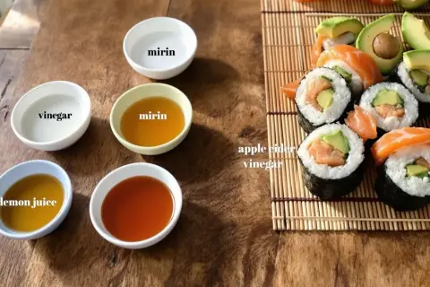 Zastanawiasz się, czym zastąpić ocet ryżowy? Na zdjęciu widać miseczki z octem, mirinem, sokiem z cytryny i jabłkowym, a obok sushi.