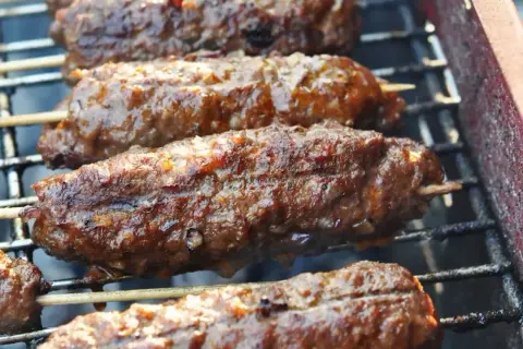 Soczyste kofta kebab na ruszcie, skwierczące i apetyczne. Idealne na letnie grillowanie.