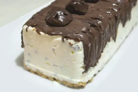 Pyszne lody cassate w czekoladzie, z kawałkami czekolady w środku, na kruchym spodzie.
