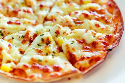 Pyszna pizza z tortilli na patelni, z ciągnącym się serem i ziołami. Idealna na szybki obiad.