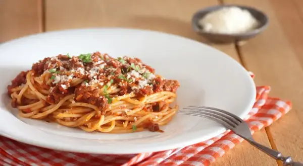 Porcja spaghetti bolognese, posypana parmezanem i natką pietruszki. Idealne na obiad, znasz już jego spaghetti bolognese kcal?