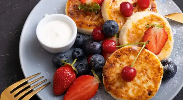 Pyszne placuszki z twarogu, idealne na śniadanie z airfryer, podane z owocami i śmietaną.