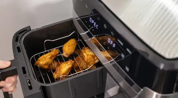 Złociste skrzydełka kurczaka w airfryerze, gotowe do podania. Pyszne dania z airfryer to szybki sposób na chrupiące przysmaki.