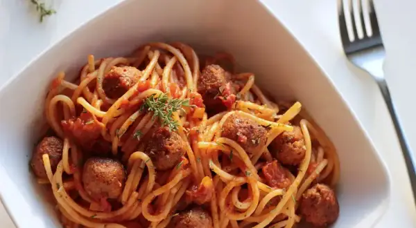 Pyszne spaghetti z klopsikami w sosie pomidorowym, doprawione ziołami. Idealne na szybki obiad, z dodatkiem przypraw do spaghetti.