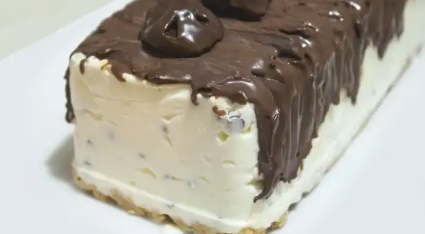 Pyszne lody cassate w czekoladzie, z kawałkami czekolady w środku, na kruchym spodzie.