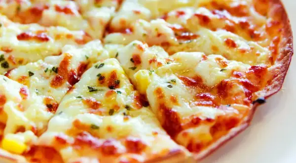 Pyszna pizza z tortilli na patelni, z ciągnącym się serem i ziołami. Idealna na szybki obiad.
