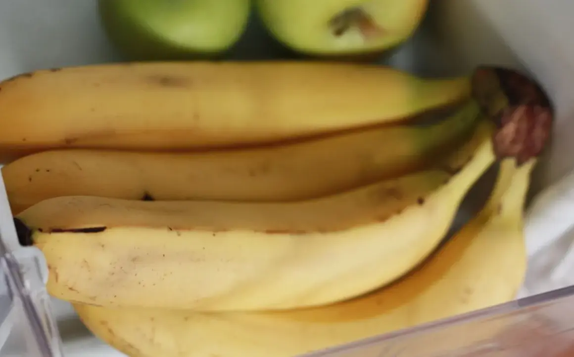 Pęk bananów w lodówce, obok zielonych jabłek. Czy banany można trzymać w lodówce? Tutaj są dowody.