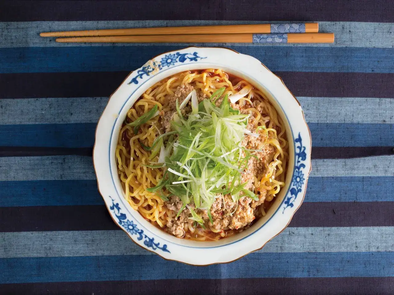 Miseczka aromatycznego tantanmen z mielonym mięsem i szczypiorkiem, gotowa do jedzenia.