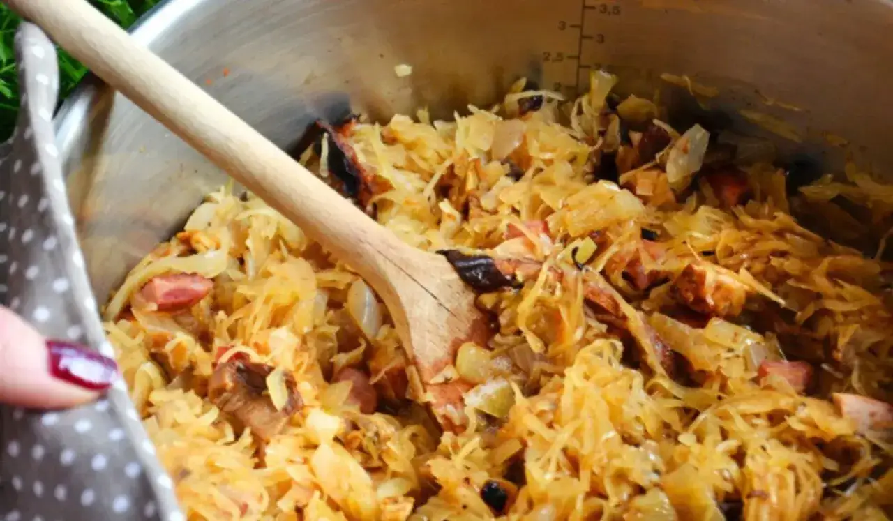 Gotujesz bigos? Zobacz, jakie mięso do bigosu nada mu najlepszy smak. W garnku dusi się kapusta z kawałkami wędzonego mięsa.