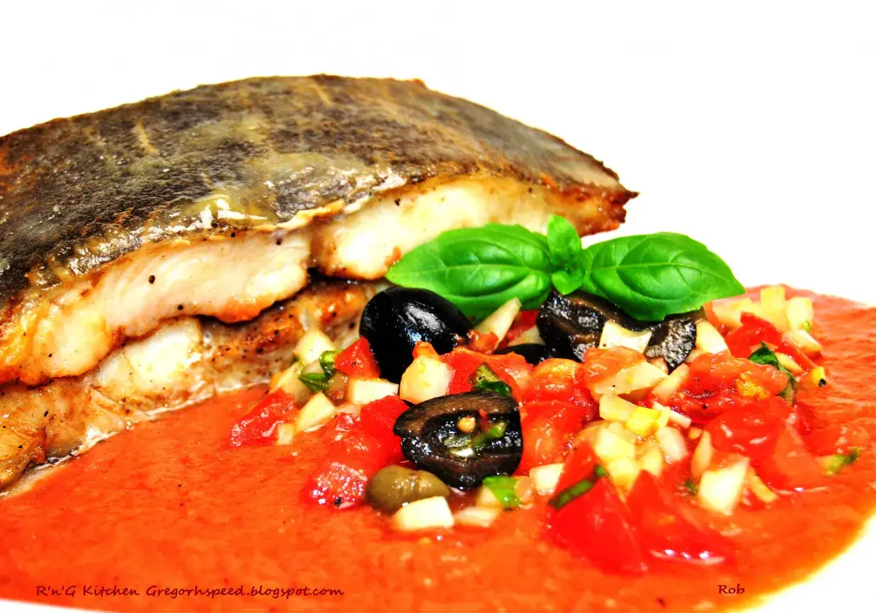 Smażony halibut ryba z salsą pomidorową, oliwkami i bazylią.