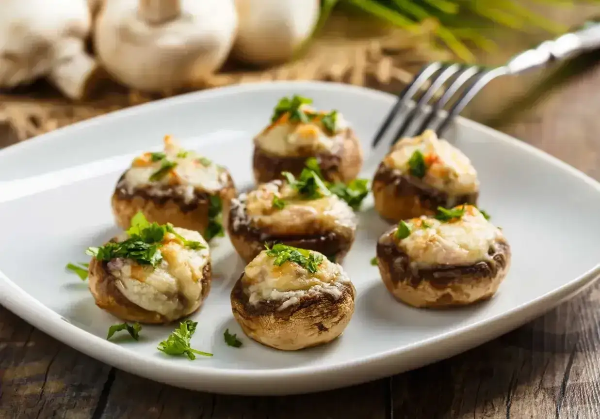 Pyszne pieczarki z grilla z ciągnącą się mozzarellą, posypane świeżą natką pietruszki. Idealna przekąska na każdą okazję.