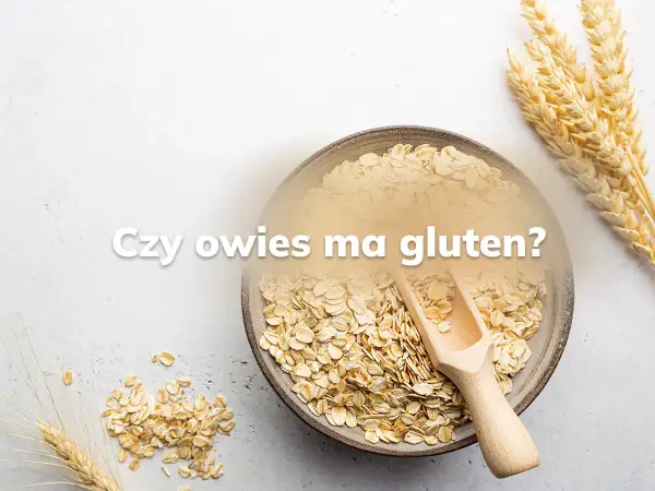 Miseczka płatków owsianych i kłosy zbóż. Pytanie "Czy owies ma gluten?" sugeruje dyskusję o jego zawartości.