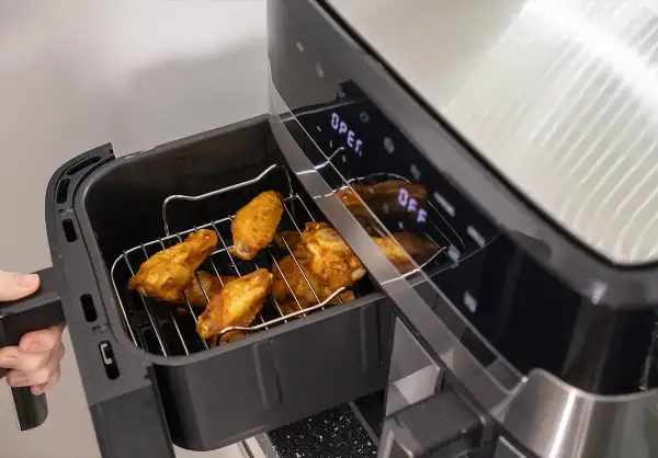 Złociste skrzydełka kurczaka w airfryerze, gotowe do podania. Pyszne dania z airfryer to szybki sposób na chrupiące przysmaki.