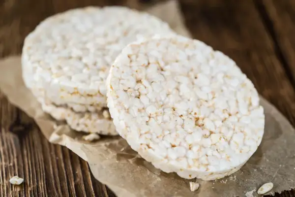 Stos lekkich wafli ryżowych na papierze, idealnych na niskokaloryczną przekąskę. Wafle ryżowe kcal to świetny wybór.