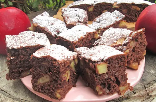 Szybkie i tanie ciasto na dużą blachę z jabłkami i kakao, posypane cukrem pudrem. Idealne na deser.