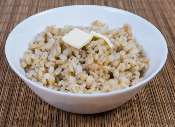 Miseczka pysznej kaszy jęczmiennej z masłem, idealna na śniadanie. Dowiedz się, jak ugotować kaszę jęczmienną krok po kroku.