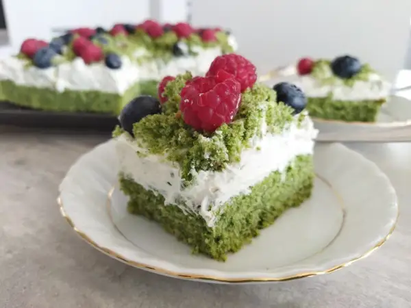 Zielony biszkopt przełożony kremem z serkiem mascarpone, udekorowany malinami i borówkami. Pyszne ciasto leśny mech na dużą blachę.