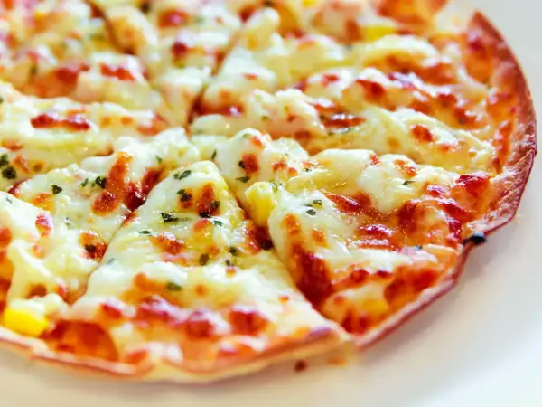 Pyszna pizza z tortilli na patelni, z ciągnącym się serem i ziołami. Idealna na szybki obiad.